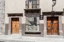Shared amenity: A building facade has two wooden doors and a central barred window.