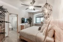 A bedroom with a bed, a window, and a ceiling fan.
