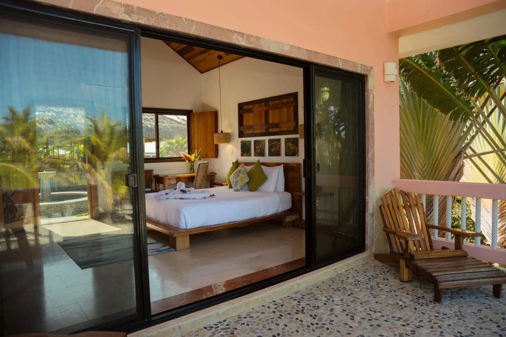 A bedroom with a bed is visible through sliding glass doors beside a balcony.