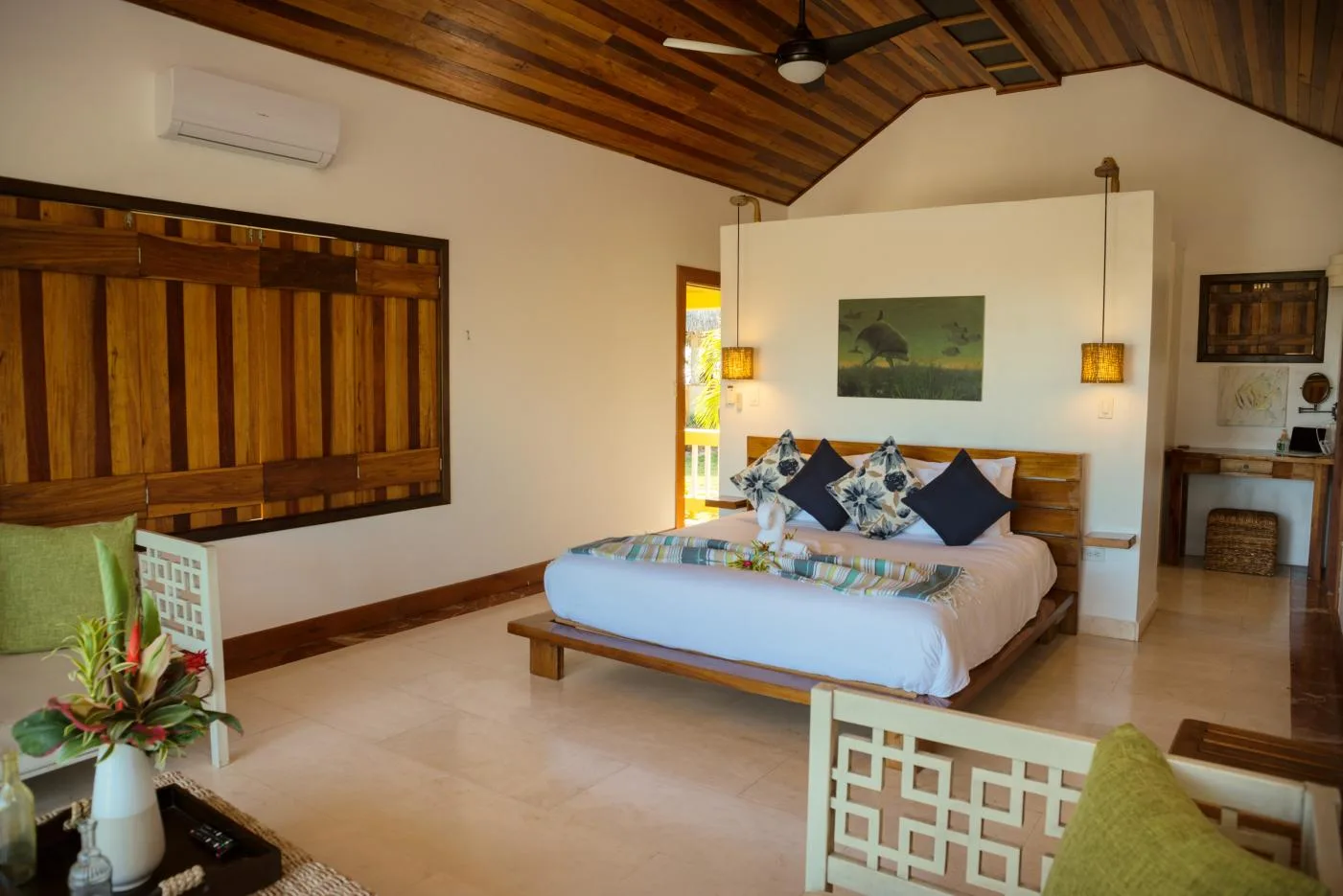 A bedroom with a bed beneath a sloped wooden ceiling.