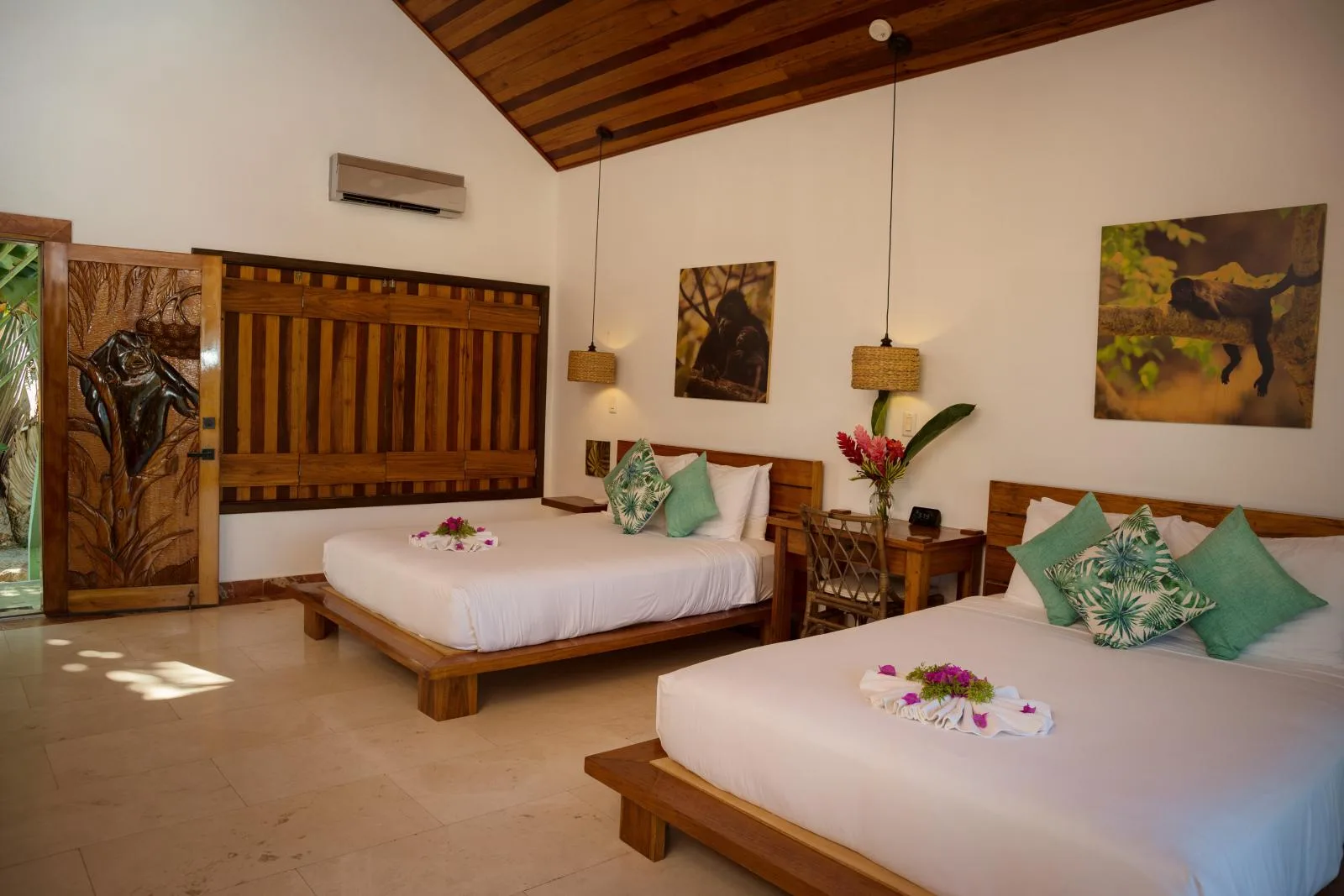 A bedroom with two beds, wooden furnishings, and wall art.