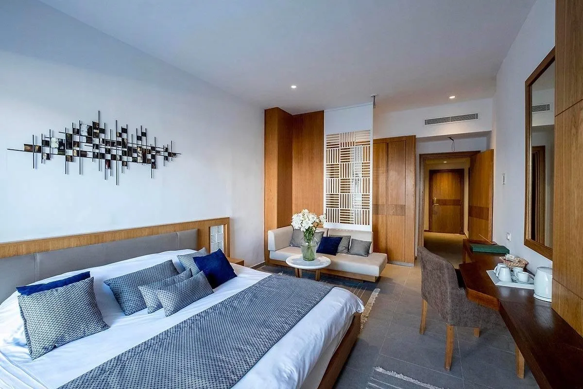 Espacio representativo del hotel: Un dormitorio de hotel con una cama grande, una zona de estar y un escritorio.
