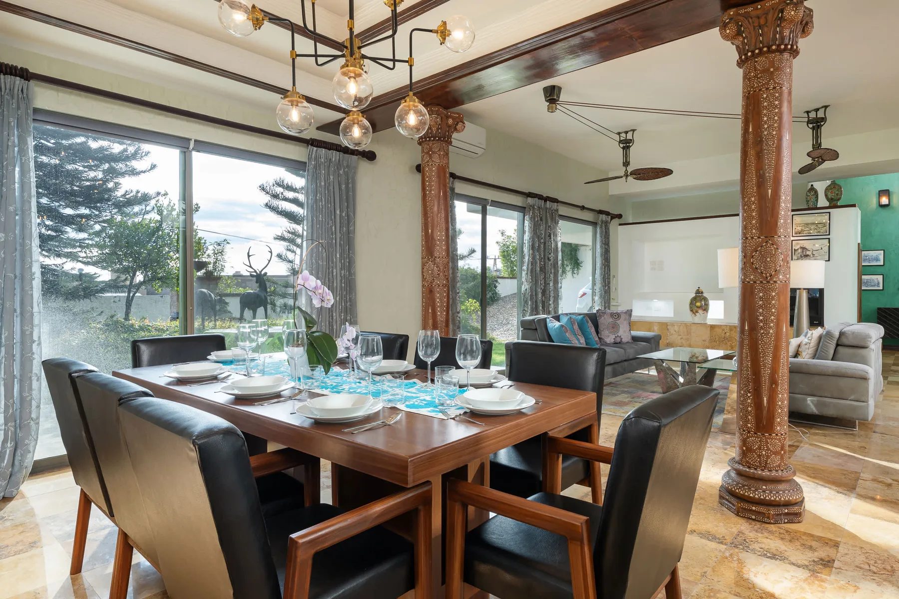 Comedor con una mesa de madera y puertas de vidrio que dan a un jardín.