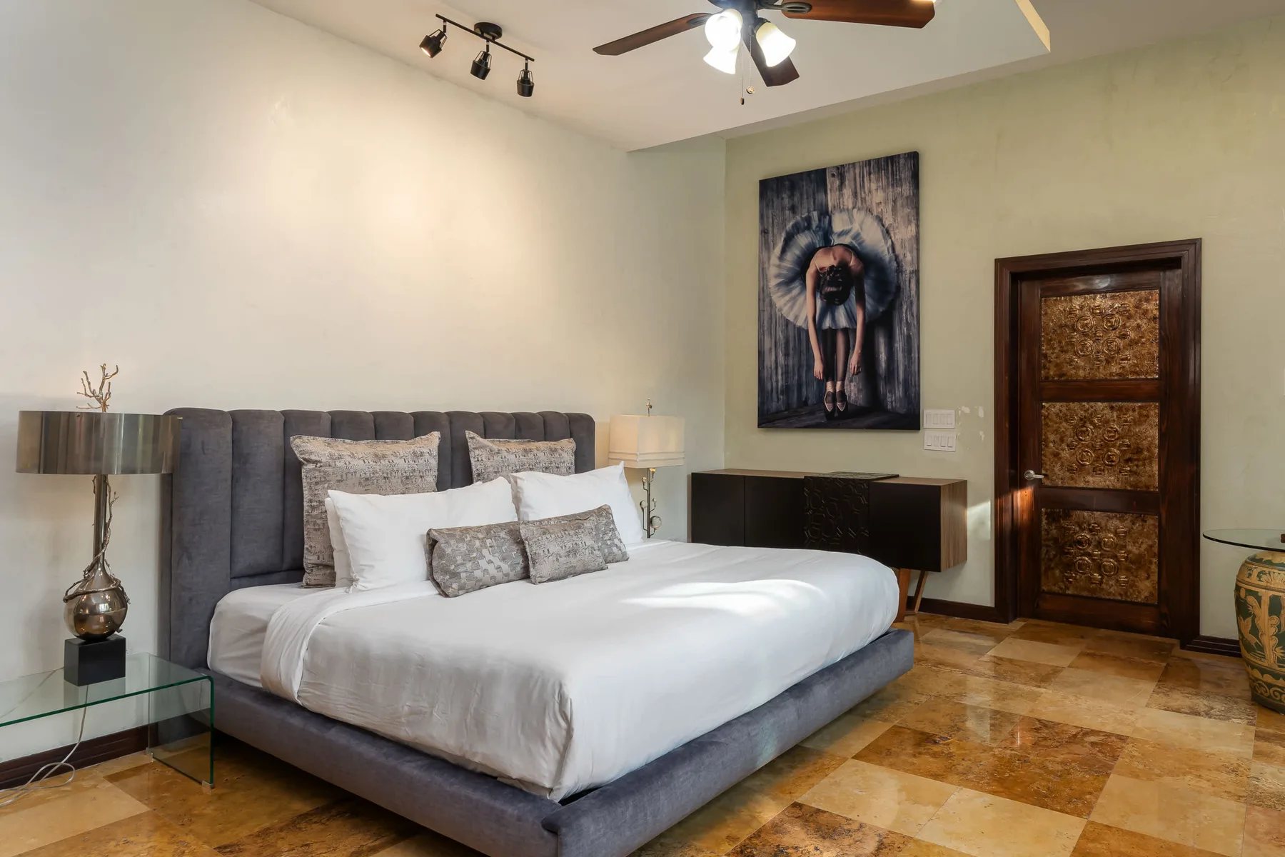 Un dormitorio con una cama grande y una obra de arte en la pared.