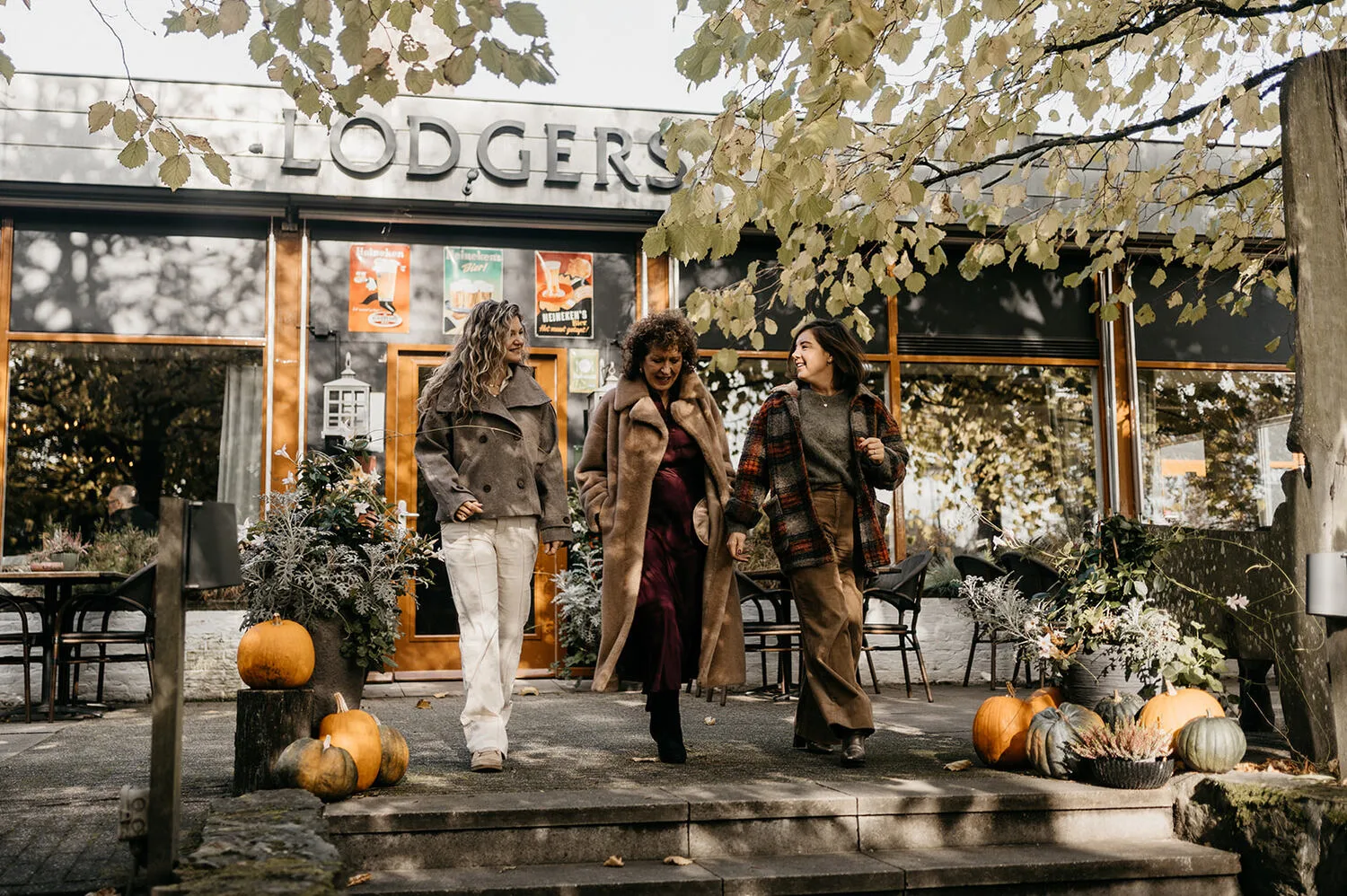Representative hotel space: Three people stand outside a shop with pumpkins arranged near the entrance.