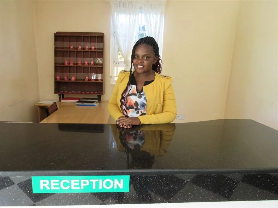 Representative hotel space: A receptionist stands behind the counter in a reception area.
