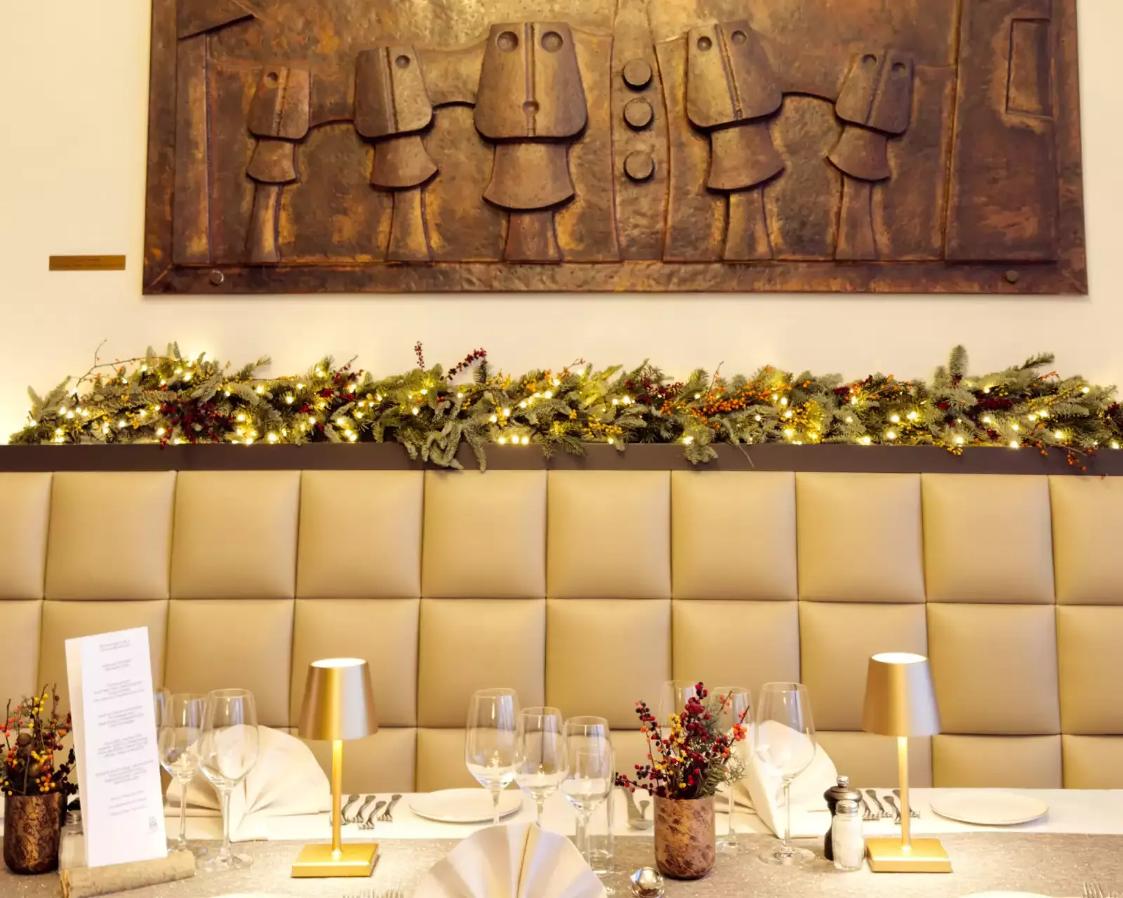 Espacio representativo del hotel: Comedor iluminado con una mesa larga preparada bajo una gran obra de arte en la pared.