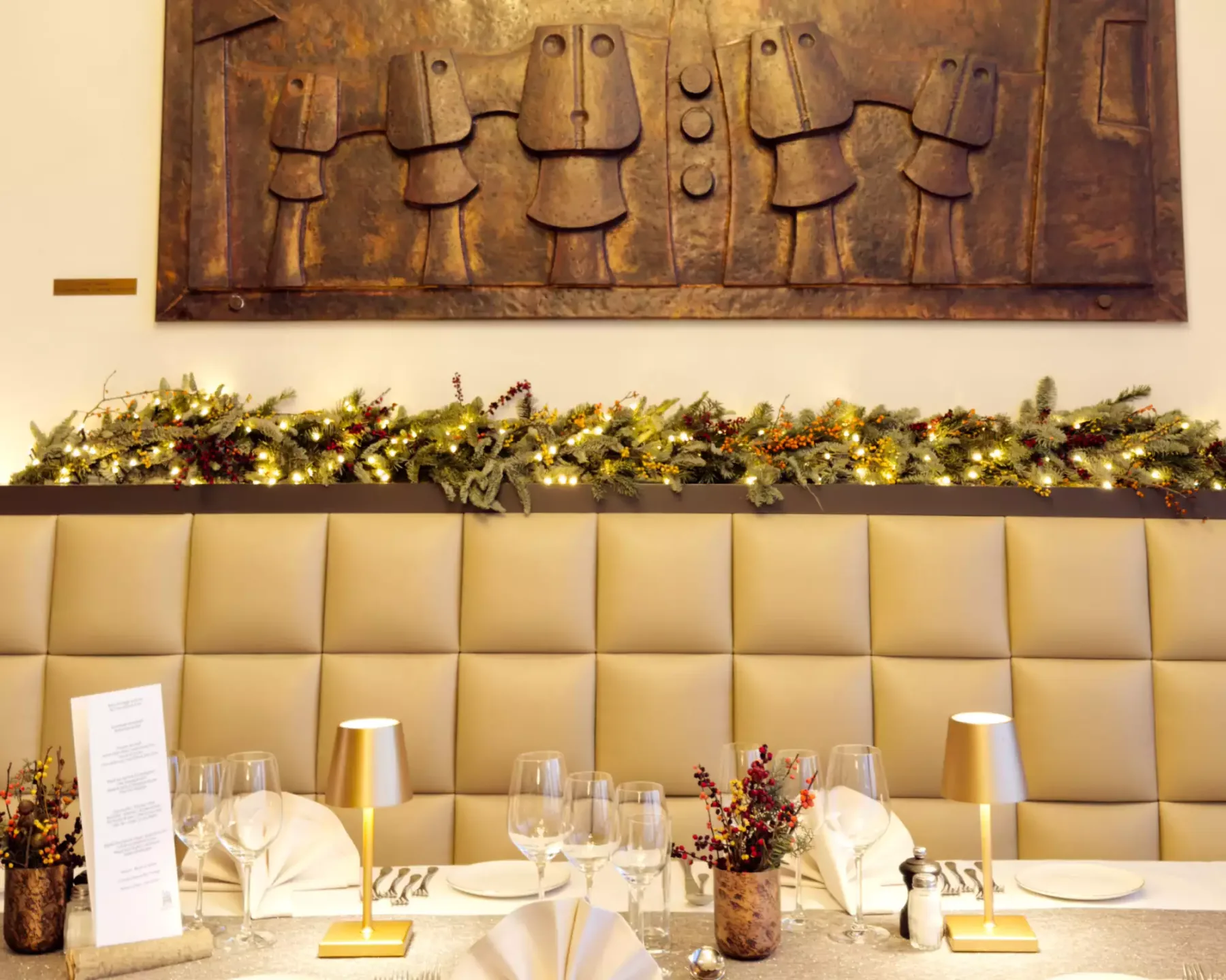 Espacio representativo del hotel: Un comedor decorado con mesas preparadas y asientos acolchados junto a la pared.
