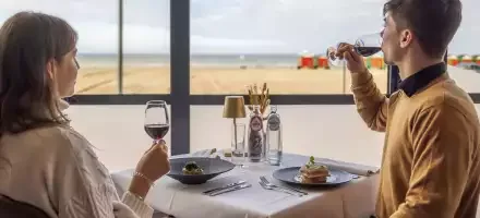 Espacio representativo del hotel: Comedor de restaurante junto a una gran ventana con vistas a la playa.