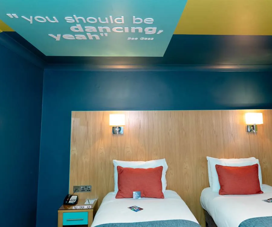 Representative hotel space: A hotel bedroom with two beds against a wood-paneled wall.