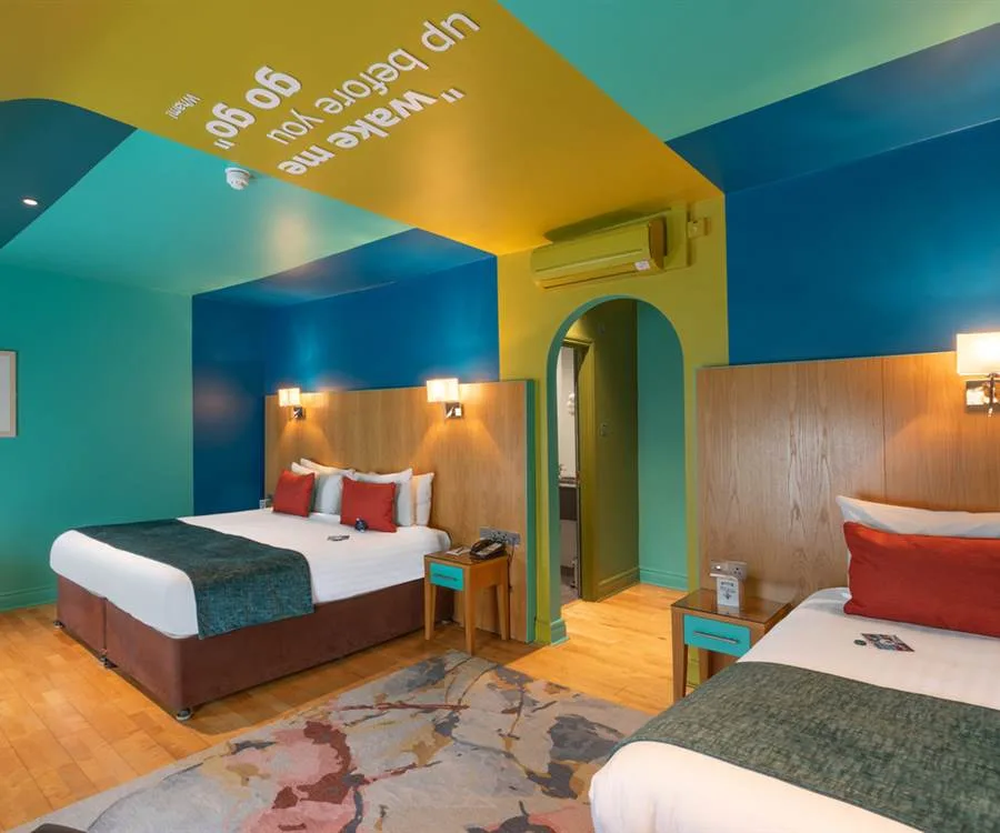 Representative hotel space: A colorful hotel bedroom with two beds and bright blue walls.
