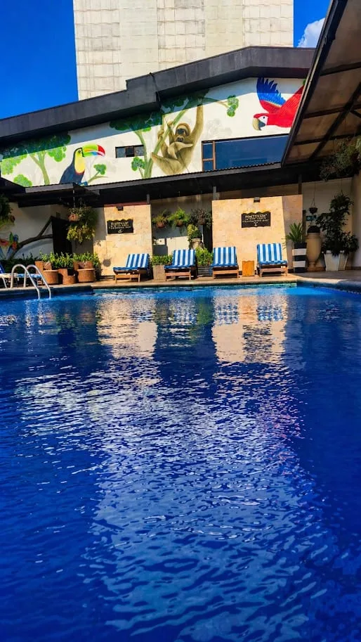 Representative hotel space: An outdoor swimming pool sits beside a mural-covered hotel building.