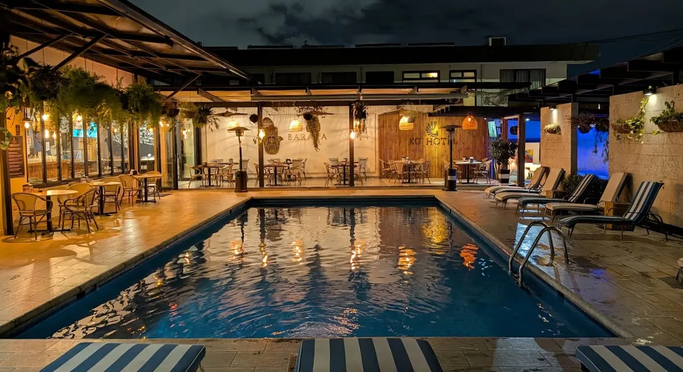 Representative hotel space: An outdoor hotel pool is surrounded by lounge seating and a covered dining area.