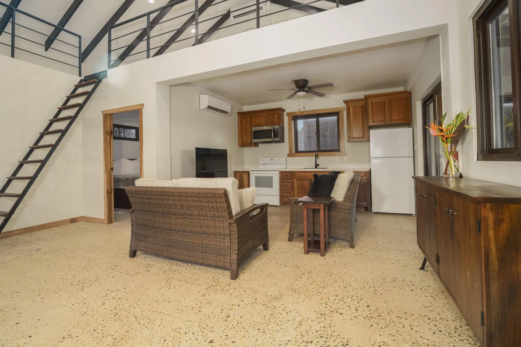 A loft-style living area with seating and an open kitchen.