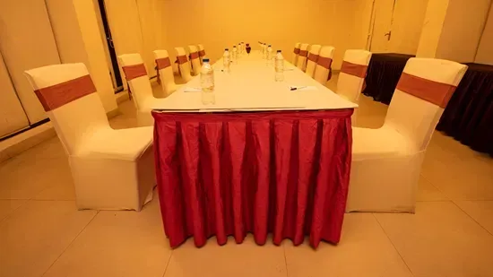 Representative hotel space: A banquet table is set with white chairs and a red table skirt.