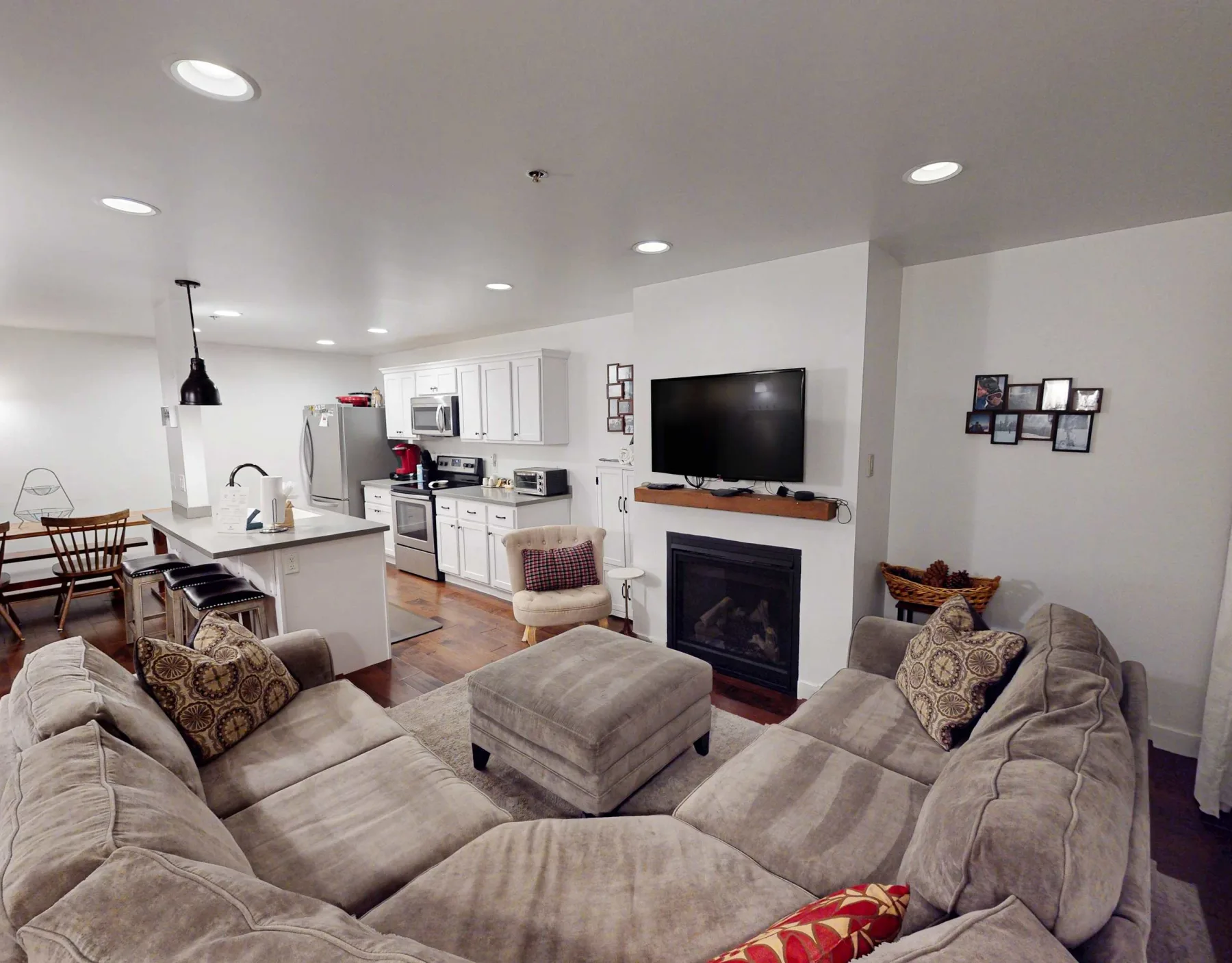 Una sala de estar con asientos, televisor y chimenea.