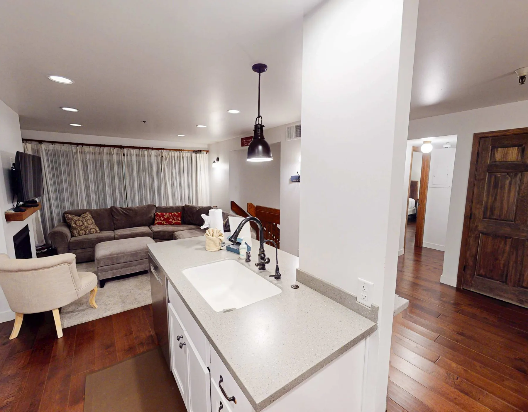 Una sala de estar abierta con cocina y un sofá seccional junto a la encimera.