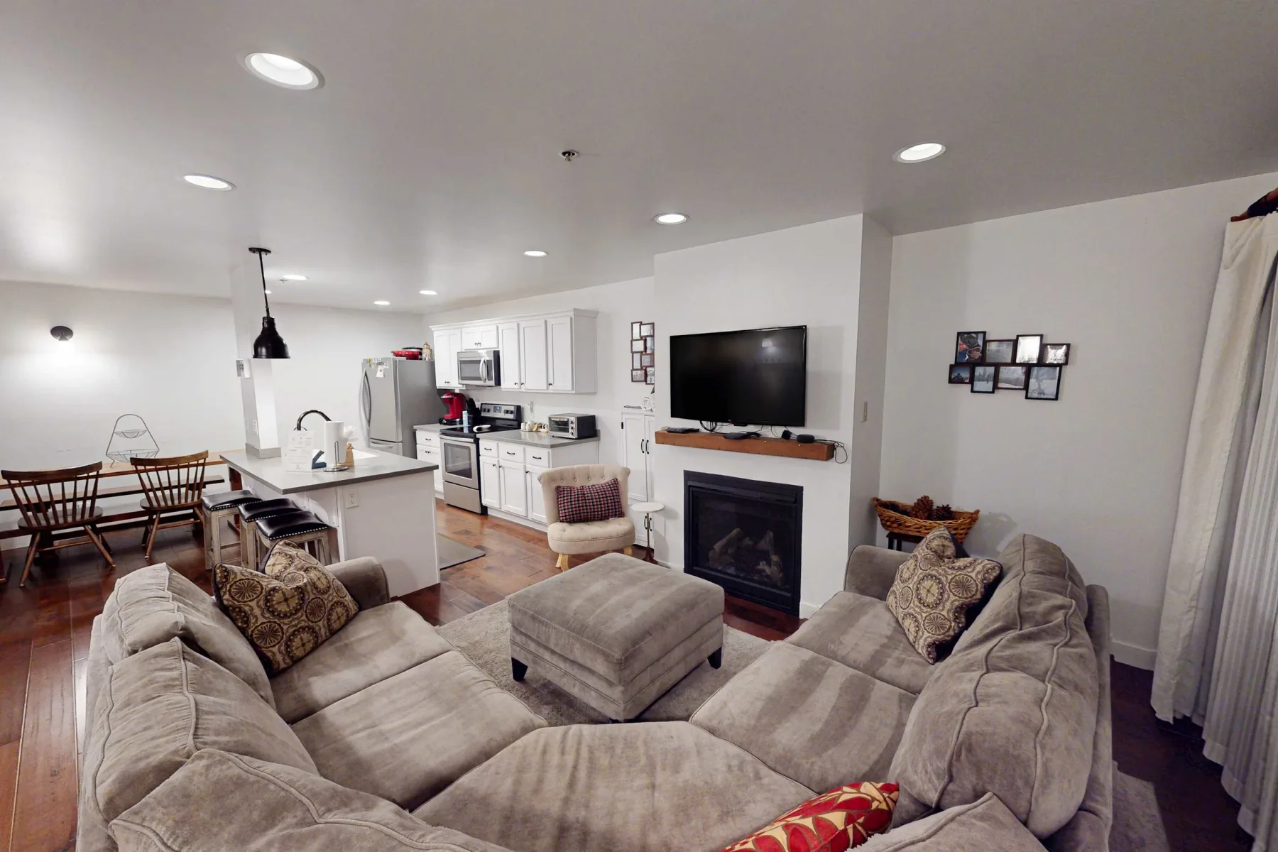 Una sala de estar con un amplio espacio de asientos frente a una chimenea y un televisor.
