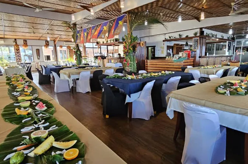Espacio representativo del hotel: Un comedor con mesas largas preparadas para comer y una mesa de buffet.