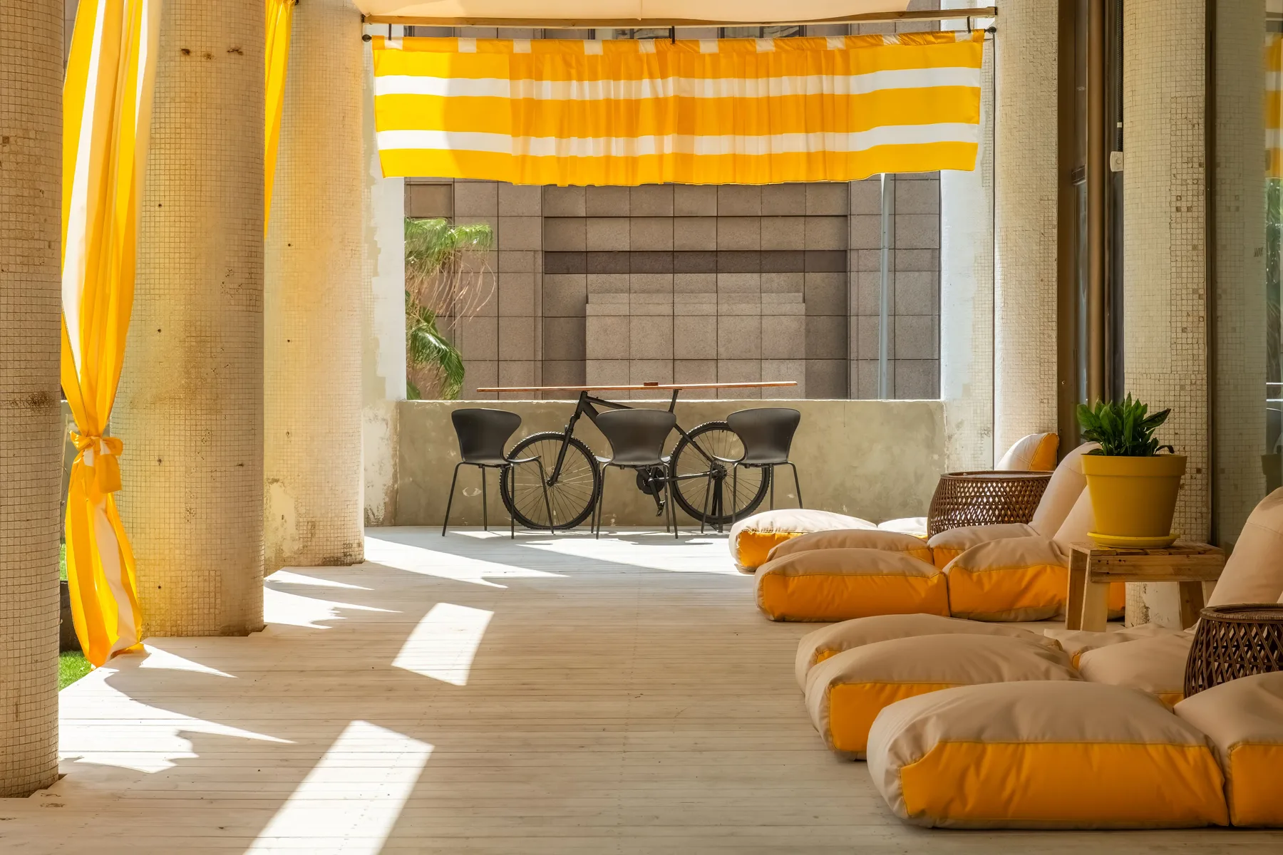 Representative hotel space: A sunlit lounge with cushioned seating and a small table.