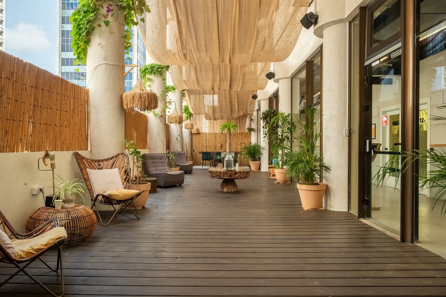 Representative hotel space: A furnished outdoor patio with seating, potted plants, and a wood deck.