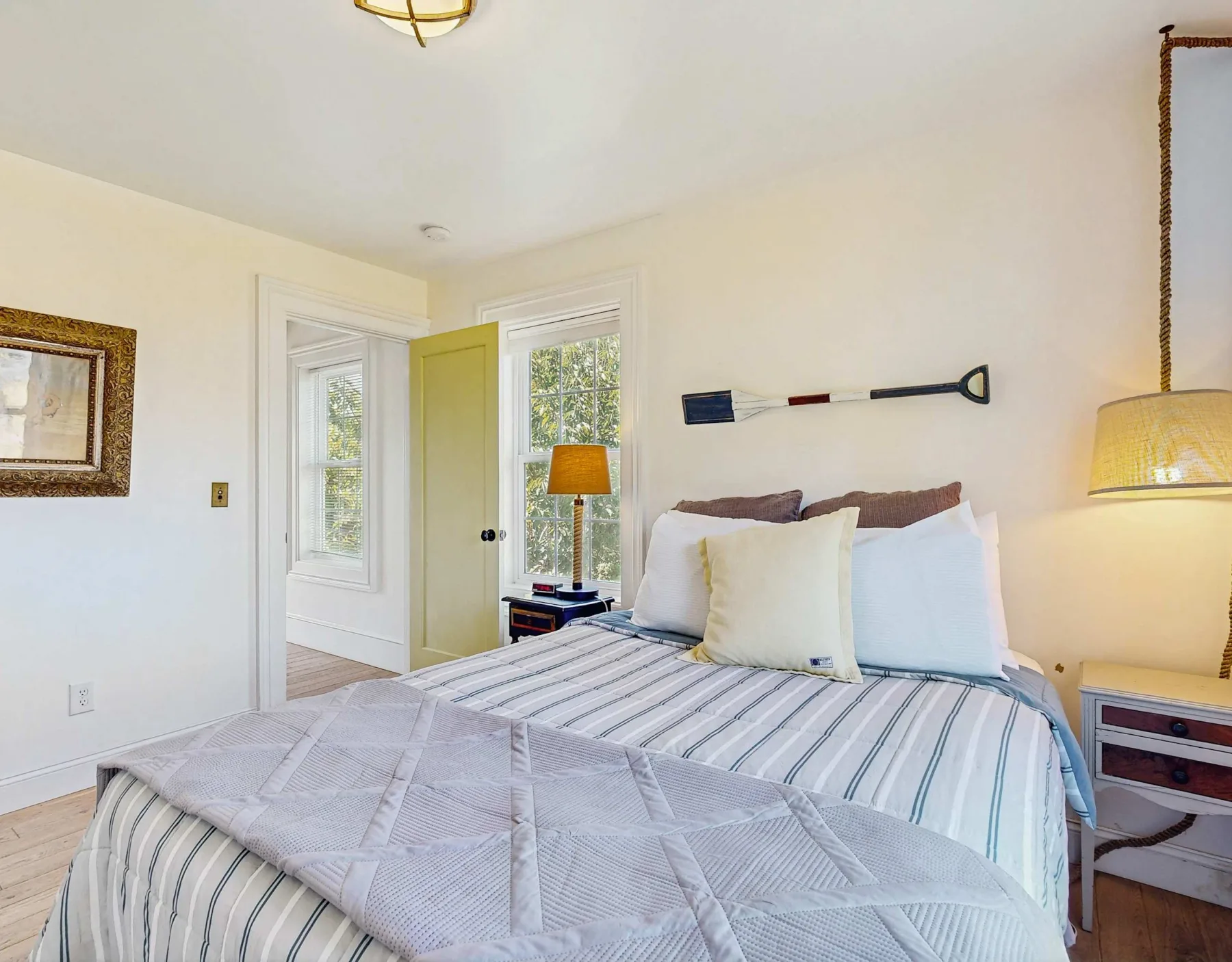 Un dormitorio luminoso con una cama hecha y una puerta abierta.