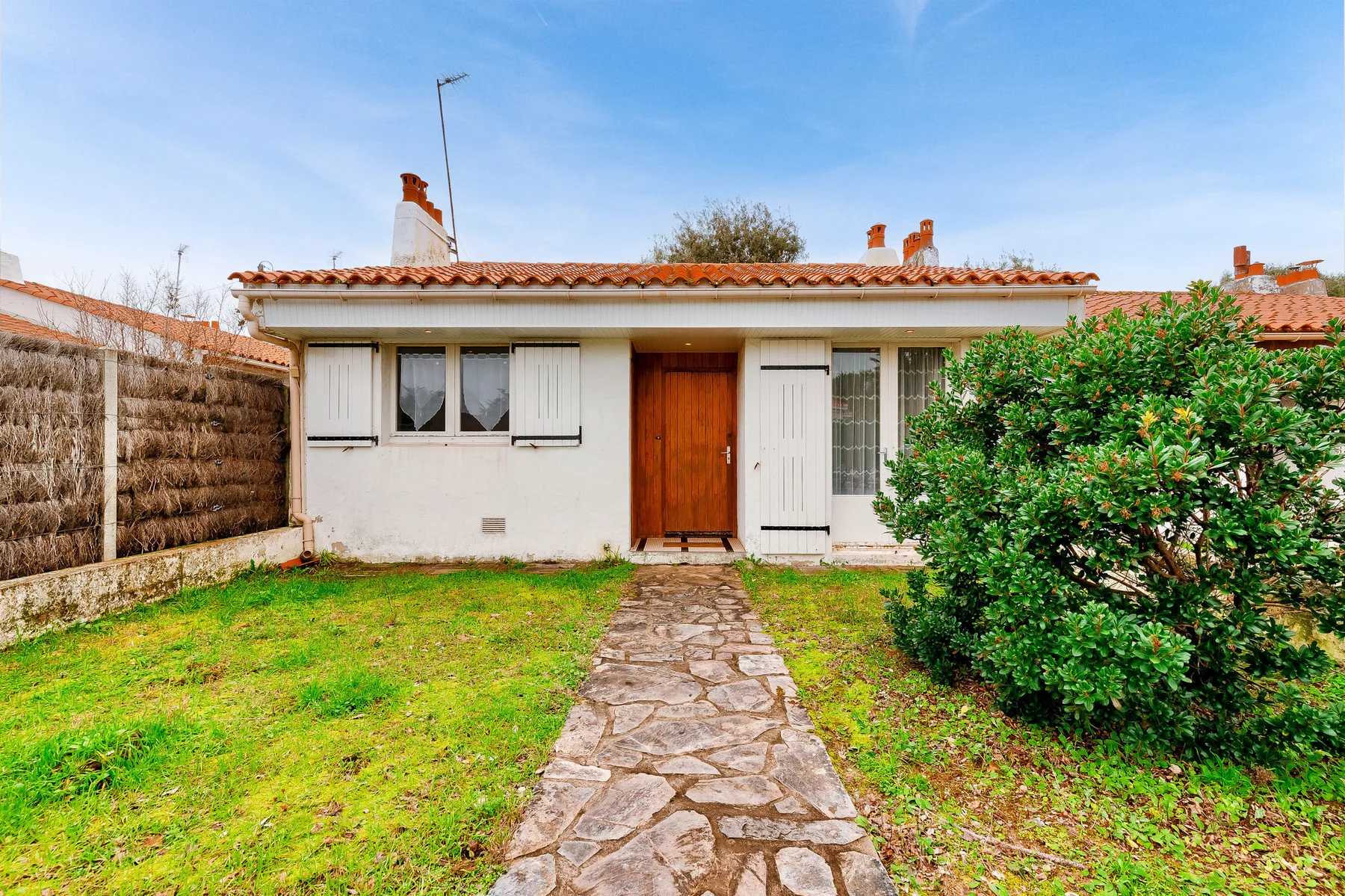 A single-story house with a stone path leading to the entrance.