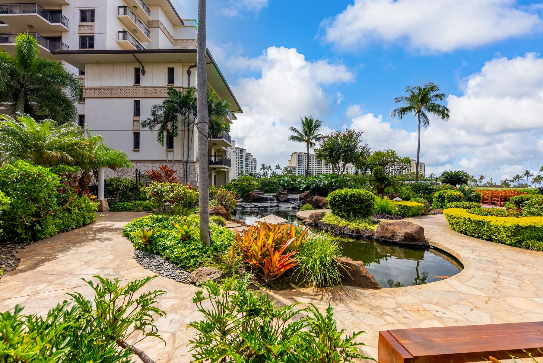 Zona común: Un patio ajardinado con senderos de piedra y un pequeño estanque.