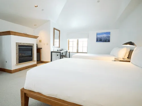 Representative hotel space: A bright bedroom with two beds and a fireplace.