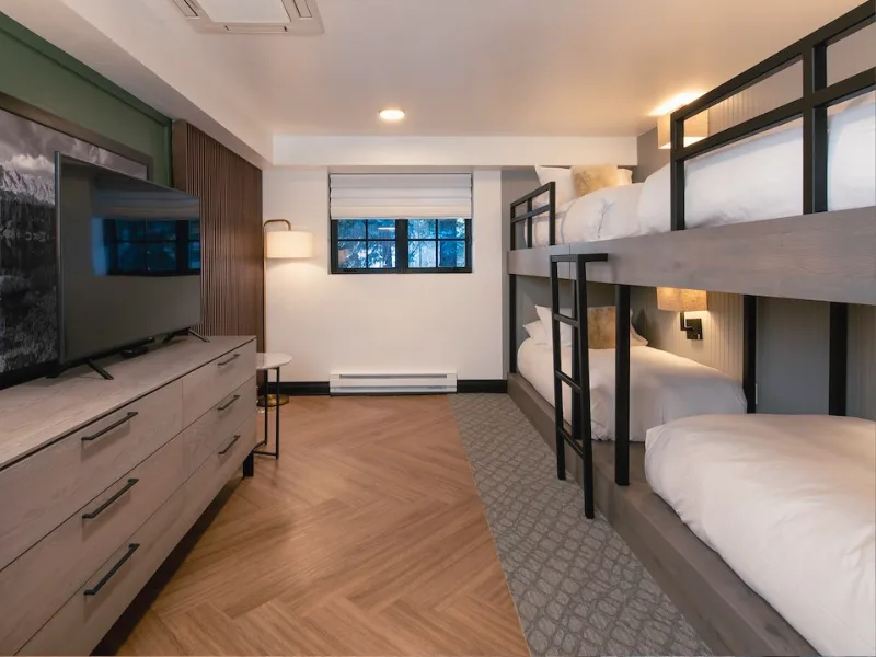 Representative hotel space: A bedroom with bunk beds, a television, and a dresser.