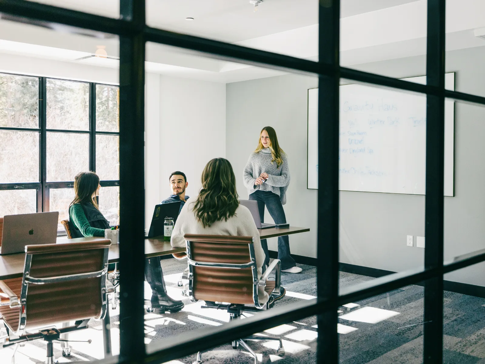 Representative hotel space: A group meets in a bright conference room with a whiteboard.