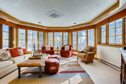Representative hotel space: A bright lounge with seating arranged around a coffee table beside large windows.