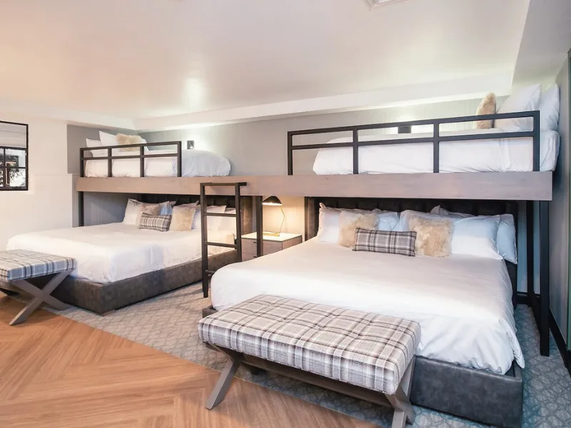 Representative hotel space: A bedroom with bunk-style beds, lower beds, and a small seating bench.