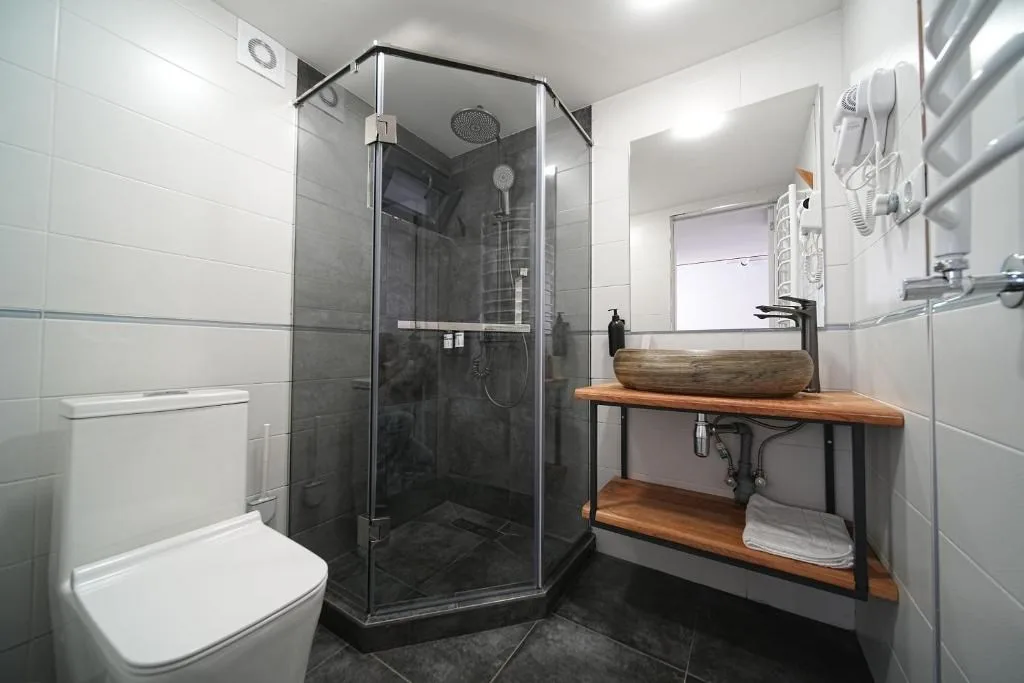 Representative hotel space: A modern bathroom with a glass shower, sink, and toilet.