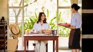 Espacio representativo del hotel: Un comedor con una persona sentada y un camarero con una bandeja.
