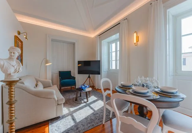 Una luminosa sala de estar y comedor con asientos, un televisor y una mesa puesta.