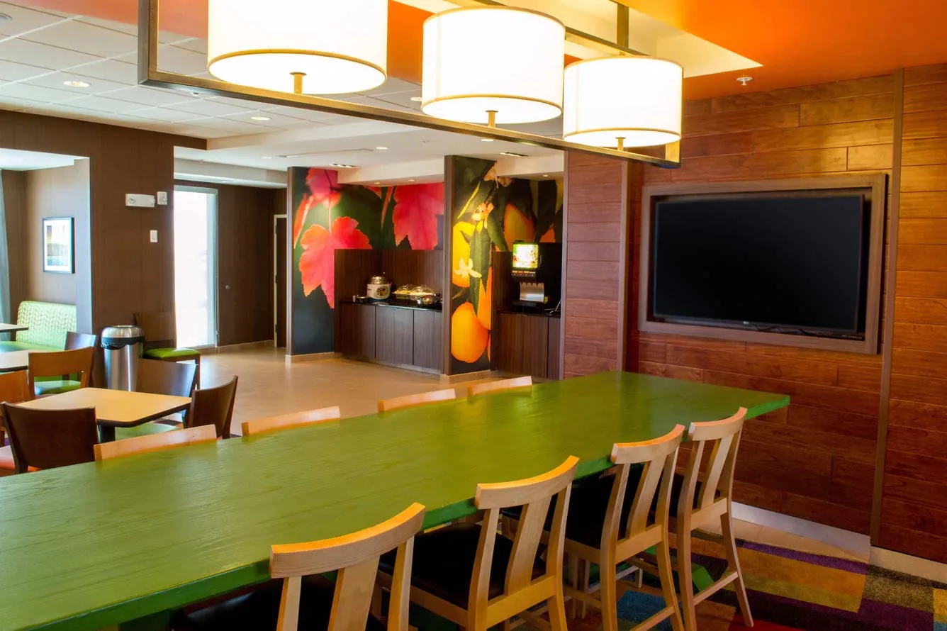 Espacio representativo del hotel: Área de comedor común con una mesa larga y un televisor en la pared.