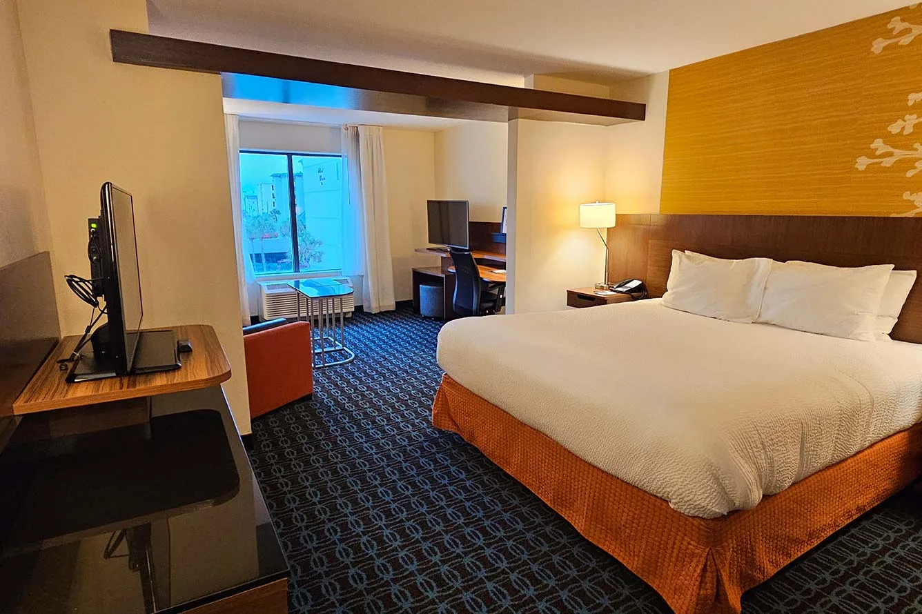 Espacio representativo del hotel: Un dormitorio de hotel con una cama grande y un escritorio junto a la ventana.