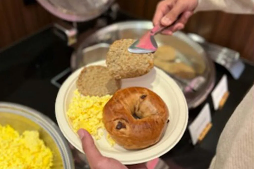 Espacio representativo del hotel: Un plato de desayuno con huevos, pan y un bollo.