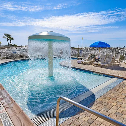 Representative hotel space: An outdoor pool has a bubbling water feature and lounge seating nearby.
