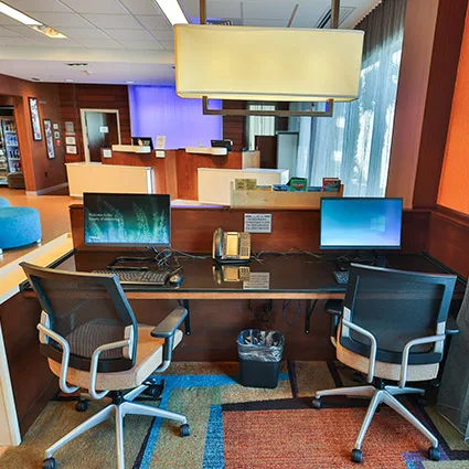 Espacio representativo del hotel: Recepción de hotel con monitores de computadora y asientos para visitantes.