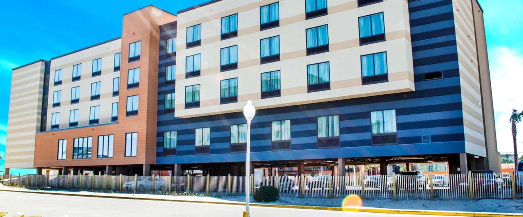 Espacio representativo del hotel: Un hotel moderno de varios pisos con paneles exteriores azules y beige.