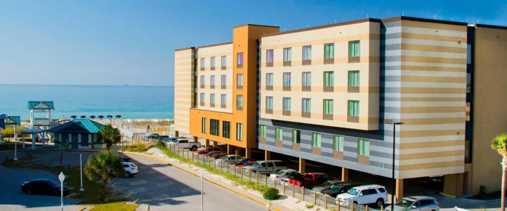 Espacio representativo del hotel: Un hotel de varios pisos se encuentra junto a la playa y el océano.