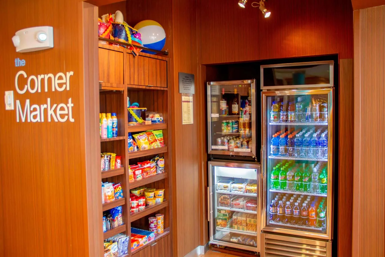 Espacio representativo del hotel: Un pequeño mercado exhibe refrigerios y bebidas junto a vitrinas refrigeradas.