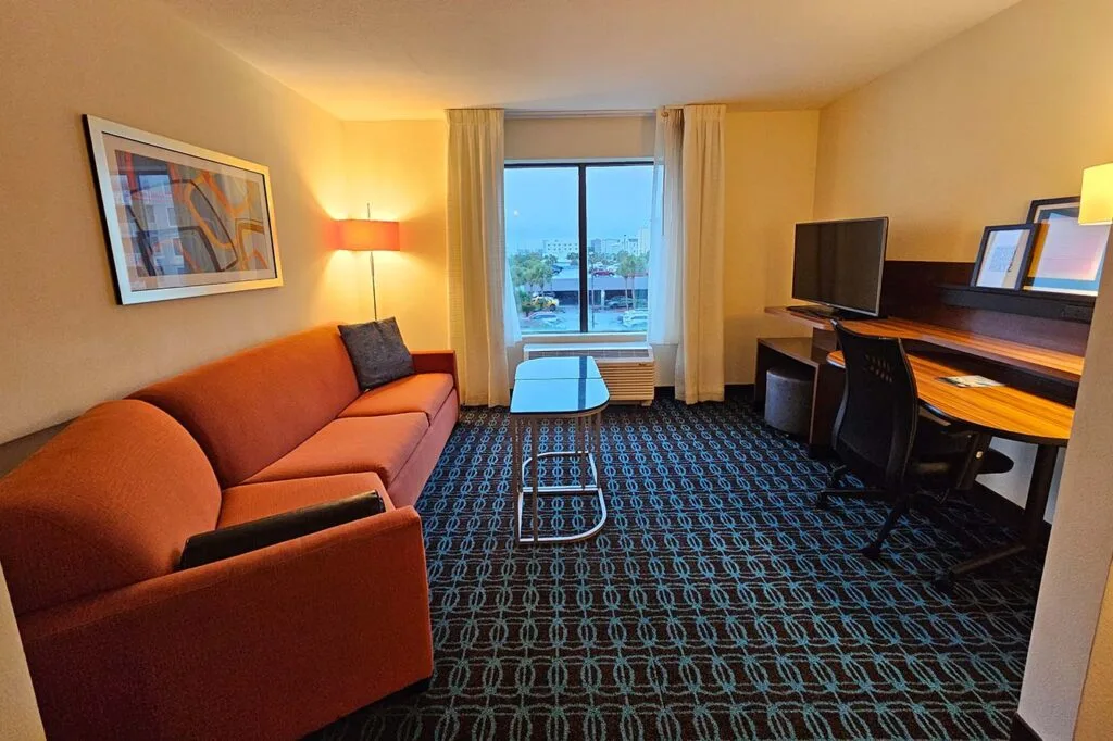 Espacio representativo del hotel: Una habitación de hotel con asientos, un escritorio y una ventana con vista a la calle.