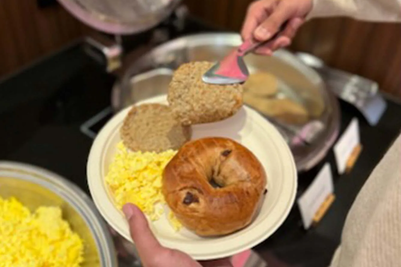 Espacio representativo del hotel: Un plato de desayuno contiene un bollo, pan y huevos revueltos.