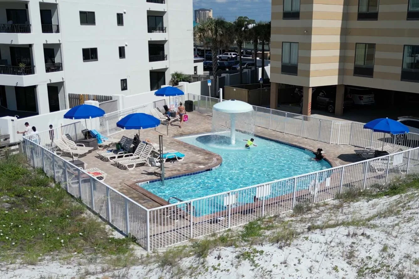 Espacio representativo del hotel: Una piscina al aire libre rodeada de asientos y edificios de apartamentos.