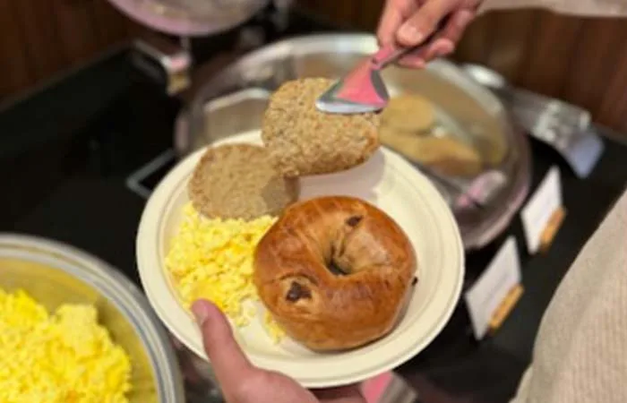 Espacio representativo del hotel: Un bufé de desayuno con un plato de huevos, pan y una porción servida.