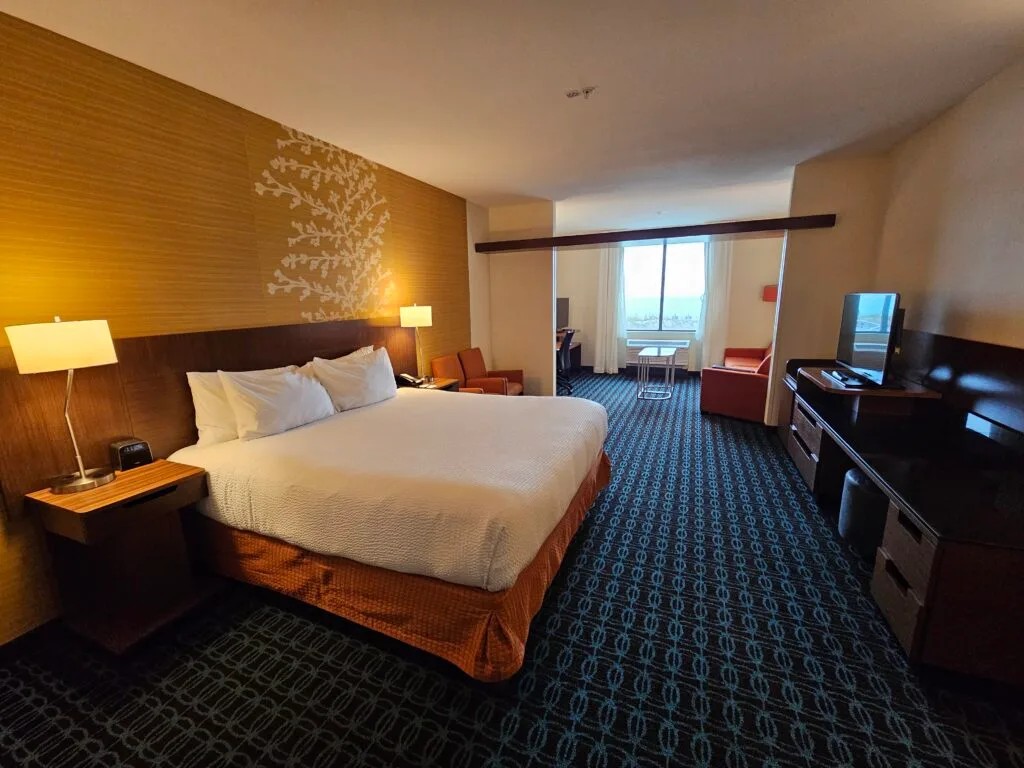 Espacio representativo del hotel: Habitación de hotel con cama, zona de asientos y televisor.