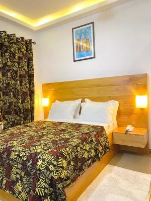 Espacio representativo del hotel: Dormitorio con cabecero de madera y ropa de cama estampada.